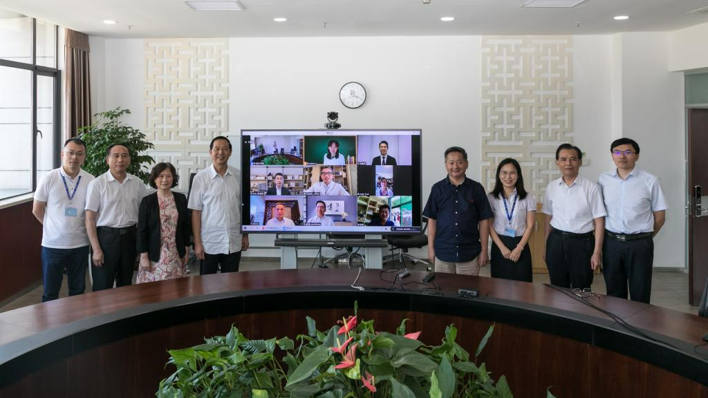 A group of people standing in front of a television Description automatically generated