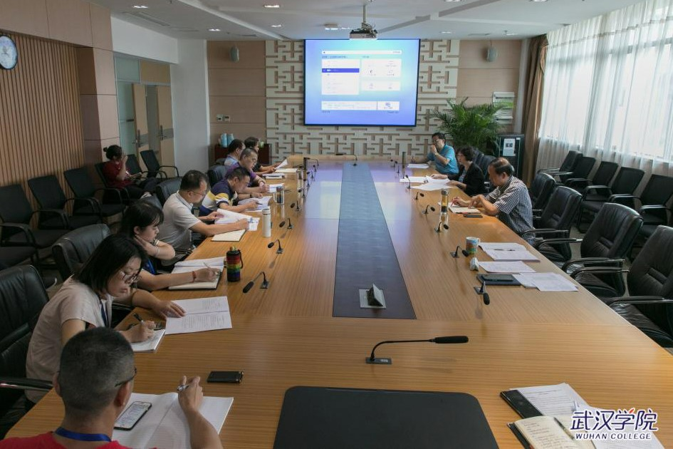 A group of people sitting at a conference table Description automatically generated with low confidence